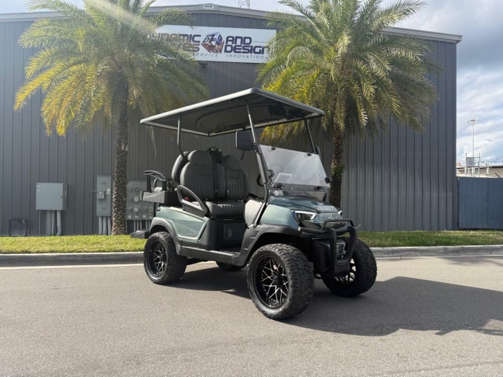 a picture of a golf cart next to two palm trees