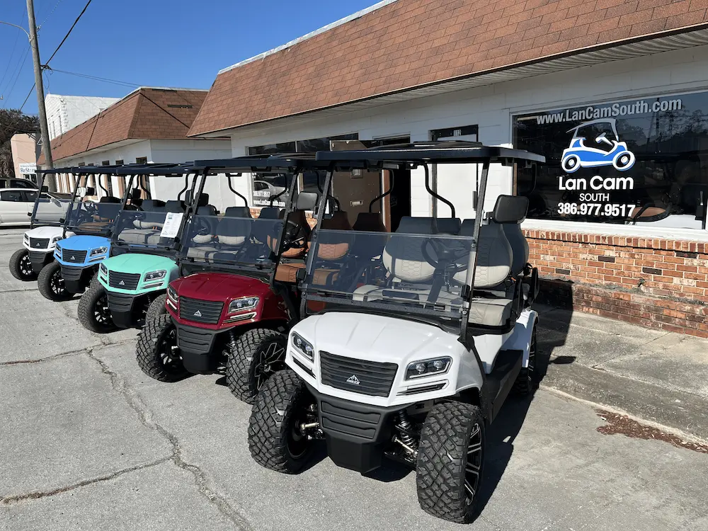 Four golf carts lined up outside a store