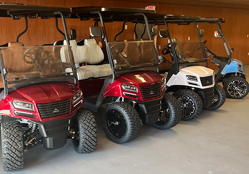 Four golf carts in a garage setting